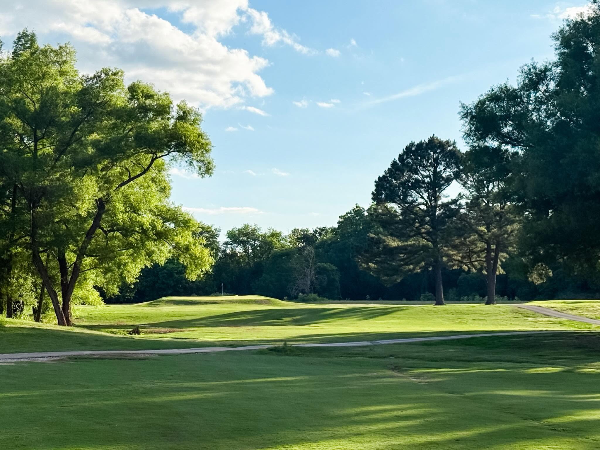 A clean striped fairway under blue sky