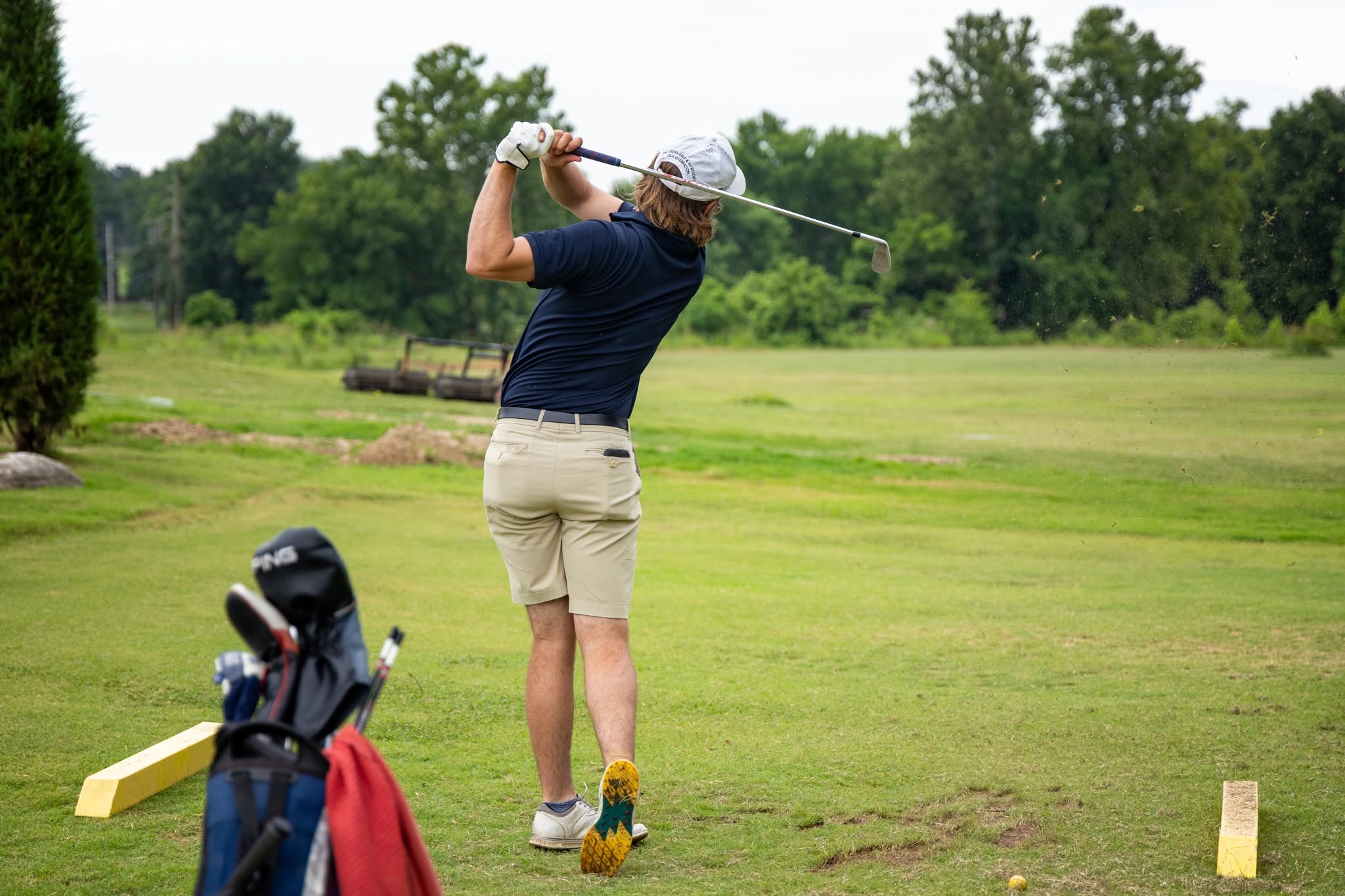 A golfer at the top of an iron swing