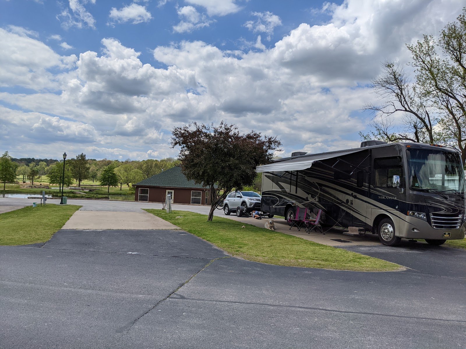 Class A motorhome set up on a paved site near the clubhouse